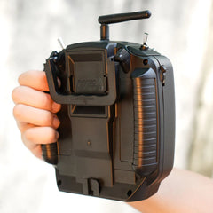 RadioMaster TX12 MKII held in one hand, showing rear grips and module bay
